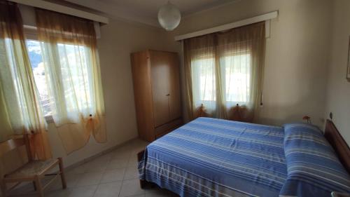 een slaapkamer met een blauw bed en 2 ramen bij Eden 96 in Camporosso