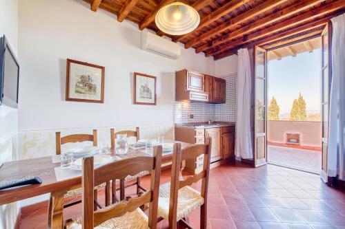 a kitchen with a wooden table and a dining room at Usignoli Apartments - Happy Rentals in Reggello
