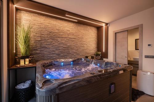 La salle de bains est pourvue d'une grande baignoire avec un mur en briques. dans l'établissement Villa Carlotta, à Vižinada