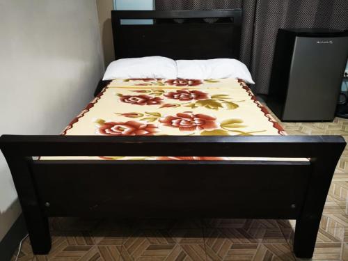 a bed with a black frame with flowers on it at BAGUIO Betty's Room Rental Couple Studio in Baguio