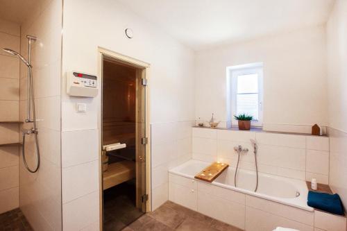 a white bathroom with a tub and a sink at Ferienhaus Diemelblick 26 in Diemelsee