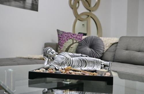 eine Statue auf einem Couchtisch im Wohnzimmer in der Unterkunft Apartamento San Sebastián in Conil de la Frontera