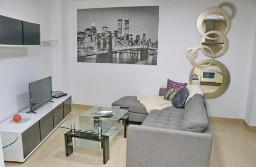 ein Wohnzimmer mit Sofa und Fernseher in der Unterkunft Apartamento San Sebastián in Conil de la Frontera