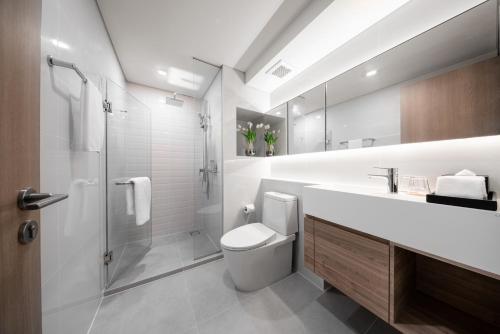a bathroom with a toilet and a sink and a shower at Ramada By Wyndham Bangkok Sukhumvit 87 in Bangkok
