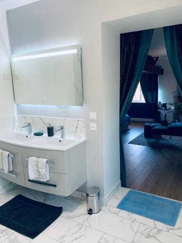 a bathroom with a white sink and a mirror at Manoir de La Gravette Authentic French Manor Experience in Montauban