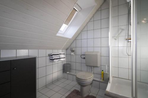 bagno bianco con servizi igienici e doccia di An der Düne 2, Whg 2 a Hörnum