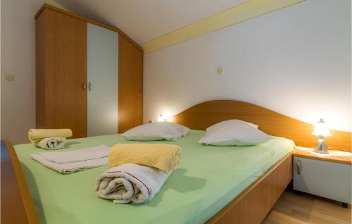 una camera da letto con un letto verde e asciugamani di Gorgeous Apartment In Barbat Na Rabu With Kitchen a Barbat na Rabu