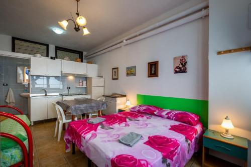 een slaapkamer met een bed en een tafel en een keuken bij Appartamentino di Romano in Gallipoli