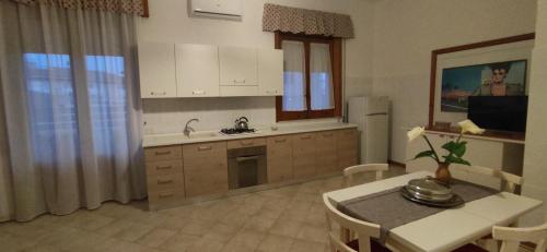 uma cozinha com uma mesa, um lavatório, uma mesa e cadeiras em Confetti di Mandorla beach house em Avola