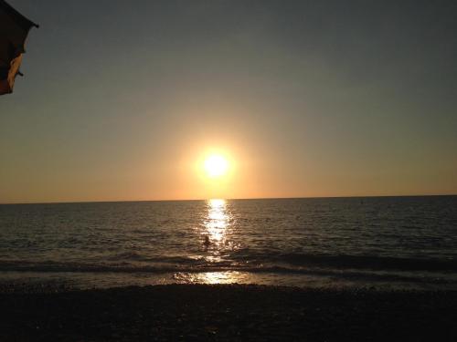 a sunset on the beach with the sun setting at Giardino Di Sicilia in SantʼAgata di Militello