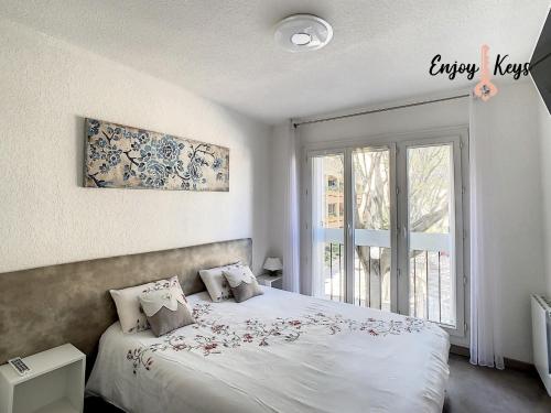 a bedroom with a bed and a large window at Au pied du Château de l'Empéri in Salon-de-Provence
