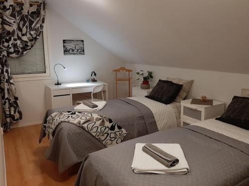 Habitación con 2 camas y escritorio. en Cosy Loft, en Helsinki