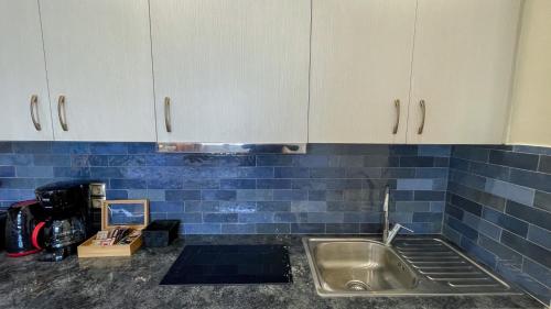 cocina con fregadero y pared de azulejos azules en Acropolis of Athens from Ermou str, en Atenas