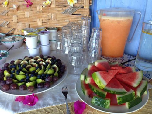 a table with two plates of fruit and a drink at Giardino Di Sicilia in SantʼAgata di Militello