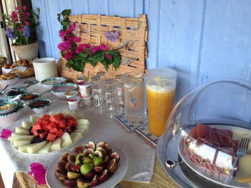 a table with plates of food and glasses of orange juice at Giardino Di Sicilia in SantʼAgata di Militello