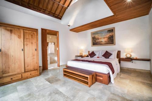 a bedroom with a large bed in a room at Gigimas Private Villa in Ubud