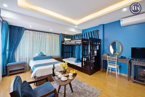 a bedroom with blue walls and a bed and a table at Pi’s Boutique Sapa in Sapa