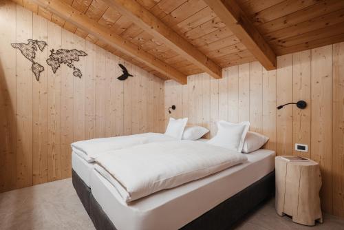 a bedroom with a bed in a wooden wall at Ciasa Willy App Conturines in La Villa