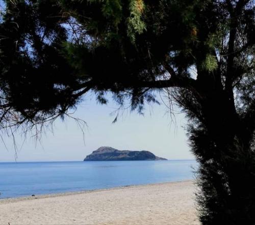 a view of a beach with an island in the water at Cozy Home (close to the beach) in Nea Kydonia
