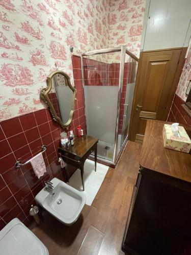 een badkamer met een toilet, een wastafel en een spiegel bij [Duomo walking distance] elegant flat with view in Milaan