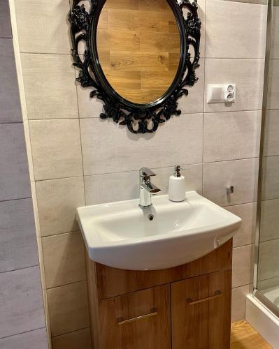 a bathroom with a sink and a mirror at Ośrodek Promenada- Faleza in Jastrzębia Góra