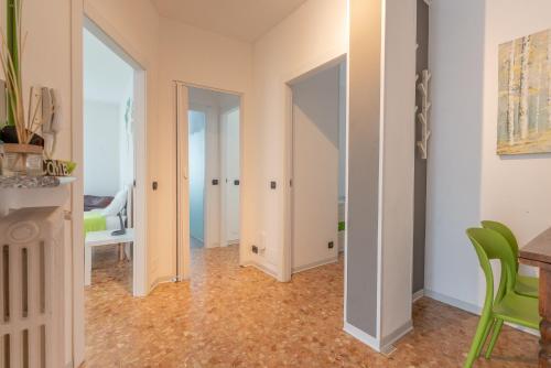 a living room with a table and a green chair at Appartamenti Matteotti 54 in Biandrate