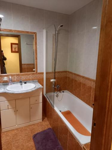 y baño con bañera, lavamanos y ducha. en Casa Rural La Cerra, en Navalguijo