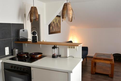 Il comprend une cuisine équipée d'une cuisinière et d'un comptoir. dans l'établissement Wohnung Steuerbord, à Timmendorfer Strand