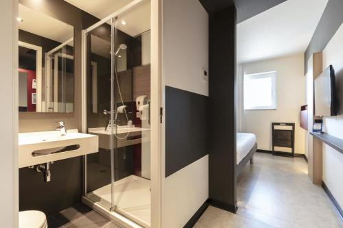 a bathroom with a shower and a sink and a mirror at ibis budget Blankenberge in Blankenberge