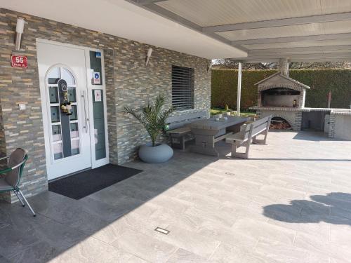 a patio with a bench and a table and a fireplace at Apartmaji Tisa in Moravske Toplice