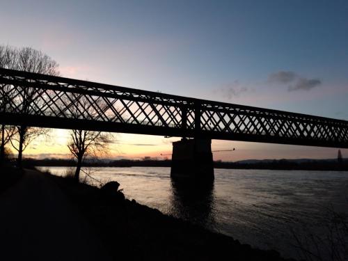 a bridge over a river with the sun setting at Bengel's Hotel zur Krone in Mülheim-Kärlich