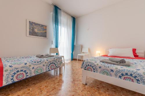 a bedroom with two beds and a window at Appartamenti Matteotti 54 in Biandrate