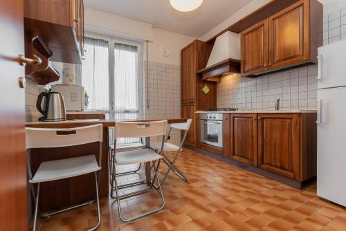 a kitchen with wooden cabinets and white appliances at Appartamenti Matteotti 54 in Biandrate