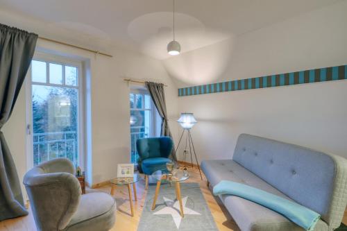 a living room with a couch and two chairs at Harz-Urlaubs-Alm Hotel & Ferienhäuser in Clausthal-Zellerfeld