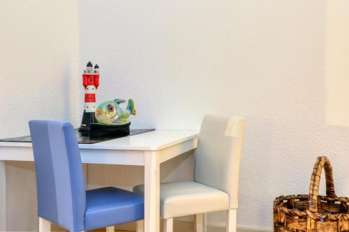 a dining room table with two chairs and a lighthouse toy at Harz-Urlaubs-Alm Hotel & Ferienhäuser in Clausthal-Zellerfeld