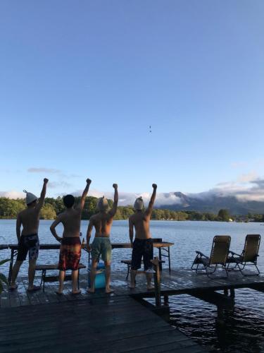 a group of men standing on a dock in the water at Lakeside Hotels Kuore in Kitashiobara