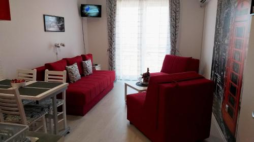un soggiorno con divano rosso e tavolo di Studio La Casa a Soko Banja