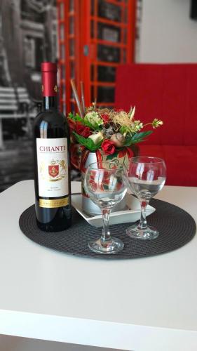 a bottle of wine and two glasses on a table at Studio La Casa in Soko Banja