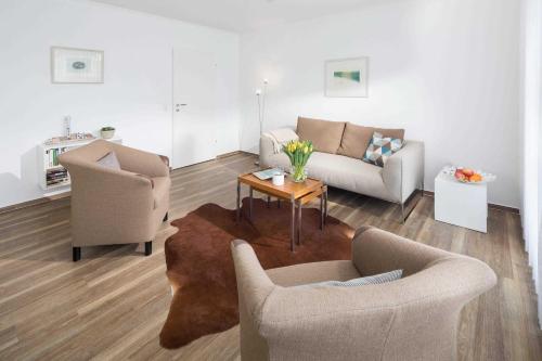 een woonkamer met twee stoelen en een tafel bij Windrose in Norderney