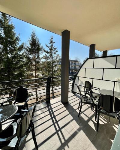 a patio with tables and chairs on a balcony at Ośrodek Promenada- Faleza in Jastrzębia Góra