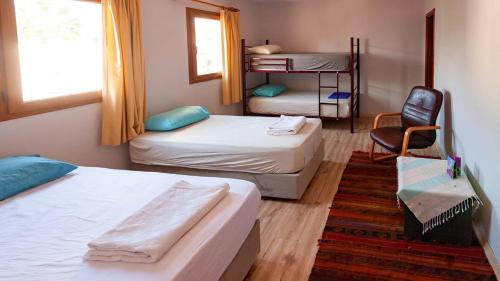 a room with two beds and a desk and a chair at La Luna Hostel in Bodrum City
