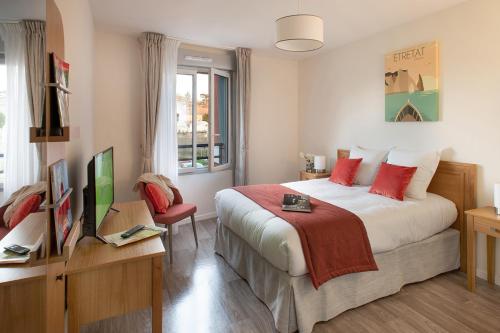 sypialnia z dużym łóżkiem z czerwonymi poduszkami w obiekcie DOMITYS LA ROZE DE SEINE w mieście Saint-Aubin-lès-Elbeuf