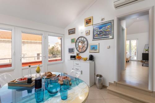 a dining room with a glass table and a window at Apartments Subrenum in Mlini