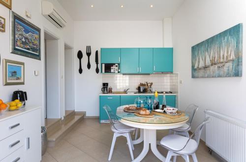 cocina con armarios azules, mesa y sillas en Apartments Subrenum, en Mlini
