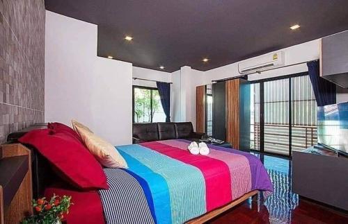 - une chambre avec un lit et une couverture colorée dans l'établissement Exotica Pool Villa Encore, à Pattaya (sud)