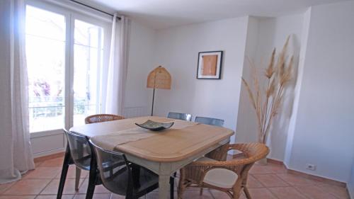 une salle à manger avec une table et des chaises en bois dans l'établissement Pasteur, à Sainte-Maxime