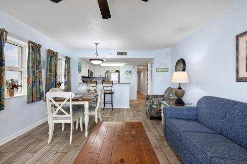 a living room with a blue couch and a table at Breathtaking Oceanfront Views - Atlantica Towers Condo in Myrtle Beach