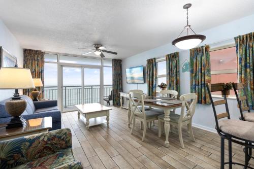 a living room with a table and chairs and a dining room at Breathtaking Oceanfront Views - Atlantica Towers Condo in Myrtle Beach