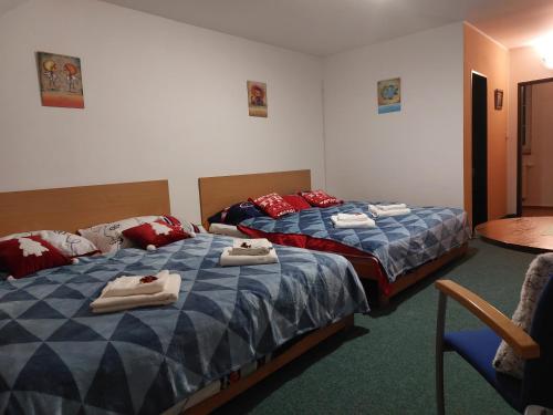 two beds in a hotel room with towels on them at Penzion Lipno Jantar in Horní Planá