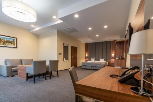 a hotel room with a reception desk and a living room at Hotel Wodnik in Bydgoszcz